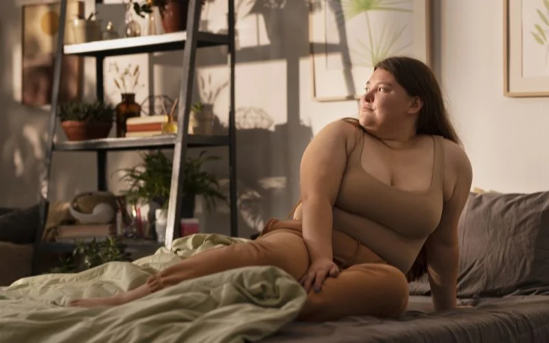 plus size boudoir photography, curvy model posing on a bed